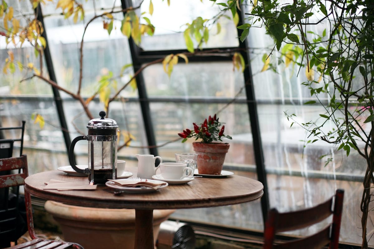 Kaffeetisch mit zwei Tassen und Stempelkanne am Fenster (Beispielbild)